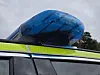 Blå takboks på taket av et kjøretøy, med gulgrønn refleksstripe under.